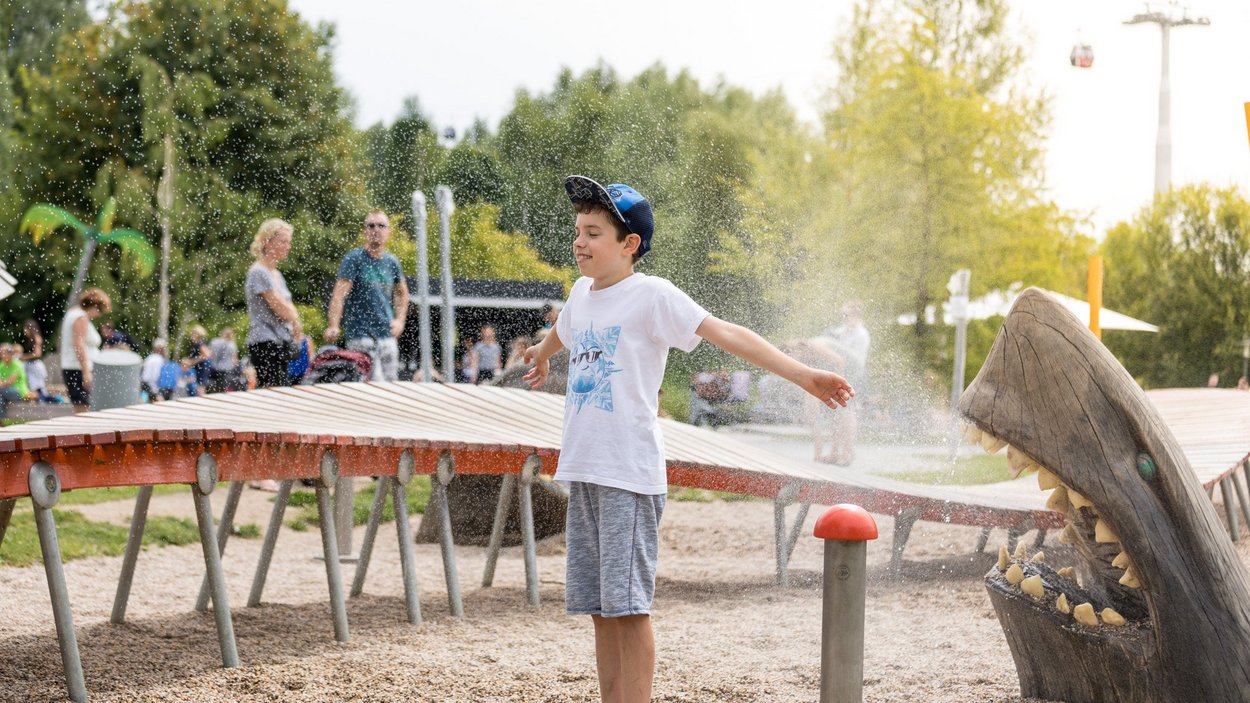 Junge spielt auf dem Wasserspielplatz in den Gärten der Welt